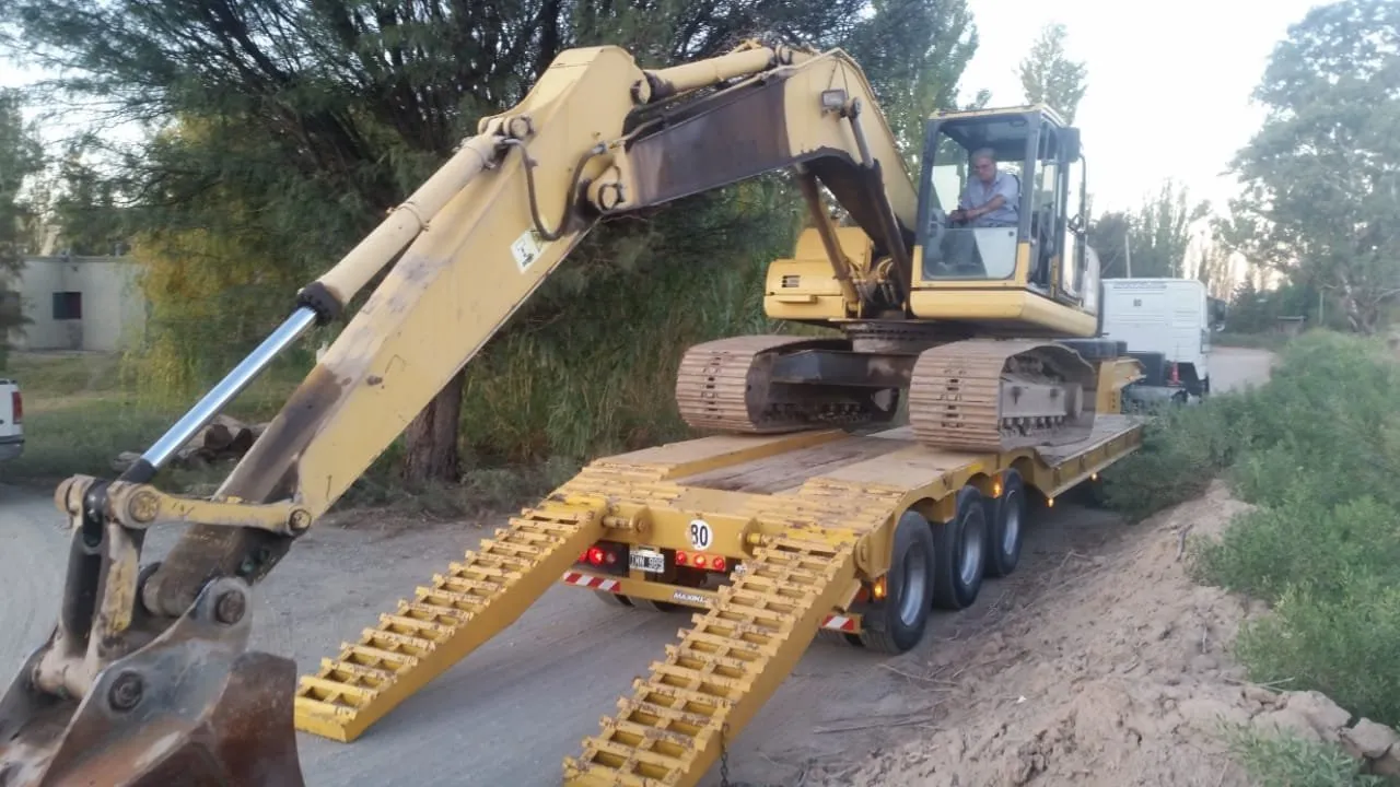 Excavadora sobre orugas subida a un carretón para su traslado